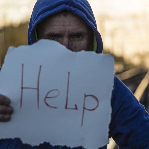 Homme tenant une pancarte noté "Help"