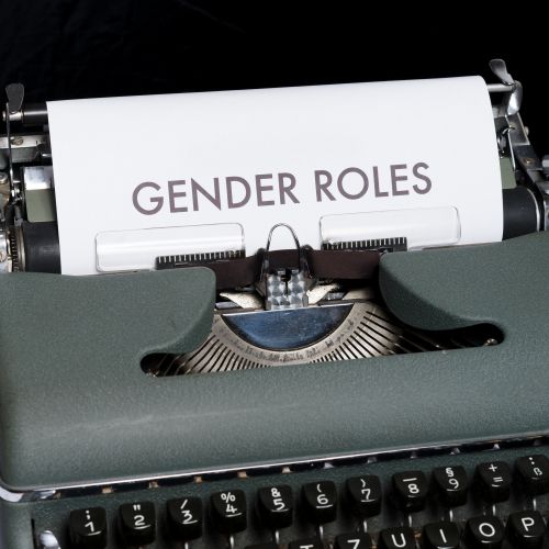 image en noir et blanc d'une machine à écrire avec une feuille sur laquelle il est écrit Gender roles